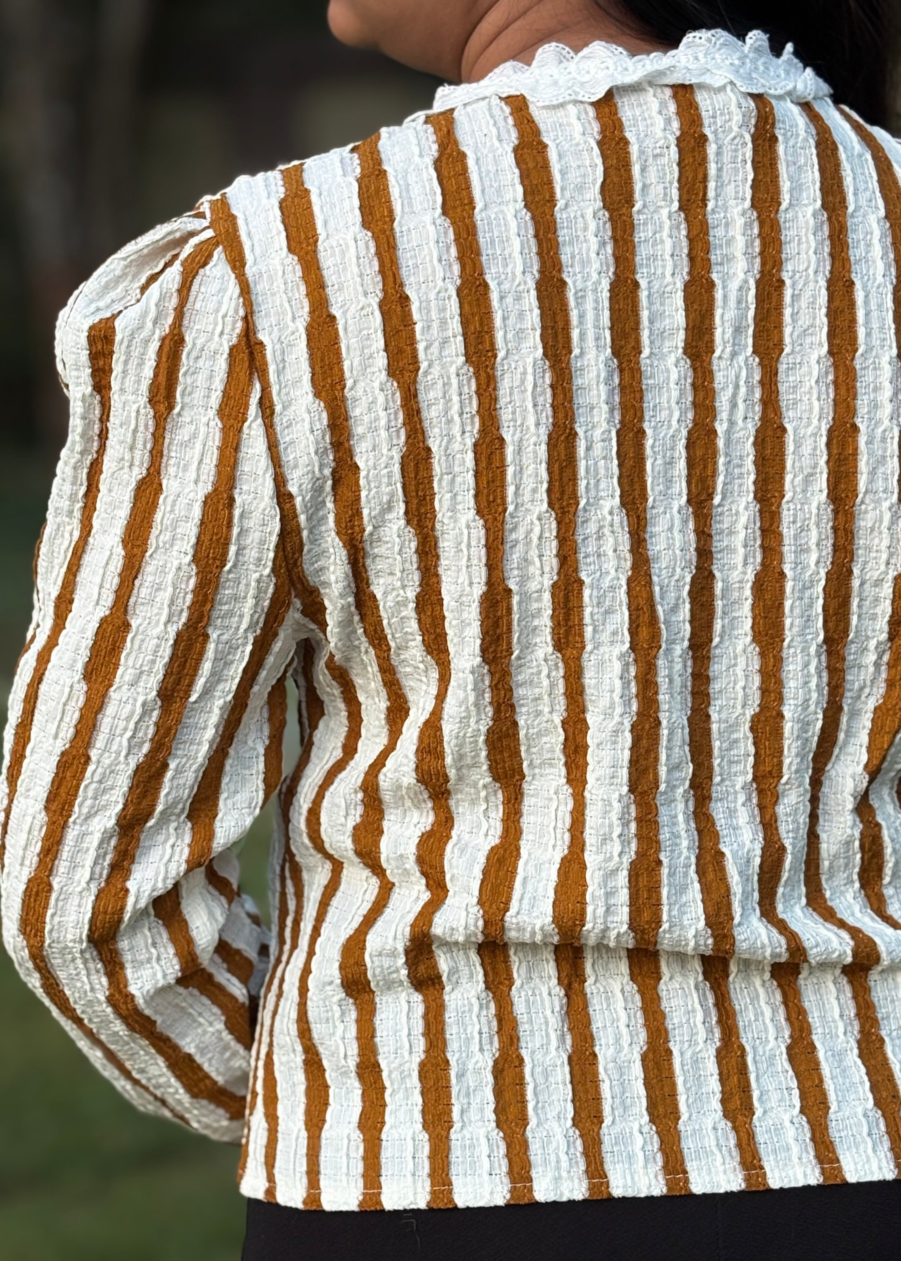 Textured long sleeve top with white and mustard vertical stripes and lace collar, worn outdoors