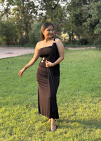 Woman wearing an elegant black one-shoulder dress with silver accents in a garden