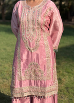 Pink embroidered kurta with gold threadwork and mirror embellishments, worn outdoors